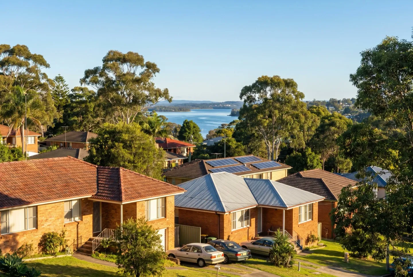 Established brick-and-tile homes on the Lake Macquarie foreshore ridge near Charlestown, the lake in the distance